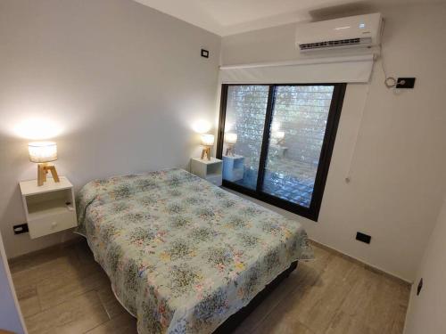 a bedroom with a bed and a large window at Departamento 3 personas in Las Heras