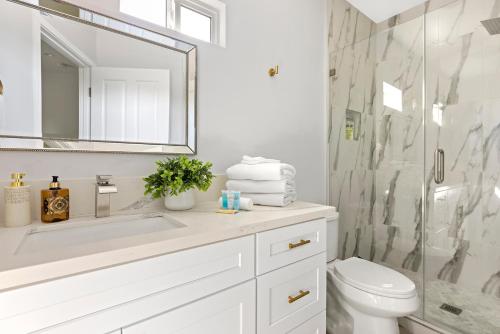 a white bathroom with a shower and a sink at Adorable 3 bedroom with Jacuzzi & more in Los Angeles