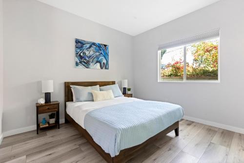 um quarto branco com uma cama e uma janela em Adorable 3 bedroom with Jacuzzi & more em Los Angeles