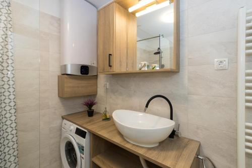 y baño con lavabo y lavadora. en Apartments with a parking space Kastel Gomilica, Kastela - 21138, en Kaštela