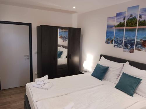 a bedroom with a large white bed with blue pillows at Apartments by the sea nska, Krk - 21205 in Malinska