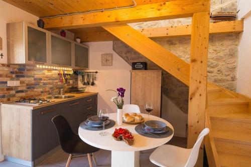 une cuisine avec une table et des chaises, accessible par un escalier. dans l'établissement Secluded house with WiFi Zlarin - 21177, à Zlarin
