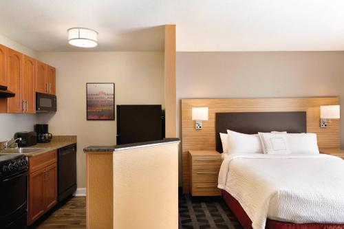 a hotel room with a bed and a kitchen at Suburban Studios Denver Tech Center in Denver