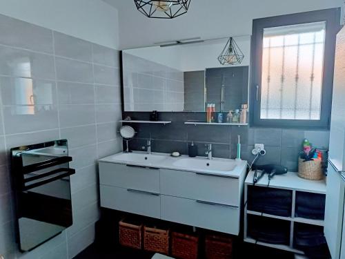 une salle de bain avec un lavabo et un miroir dans l'établissement Villa contemporaine Piscine chauffée,pétanque, Clim, à Ceyreste