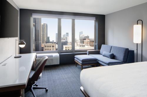 a hotel room with a bed and a chair and a window at Courtyard by Marriott Chicago Downtown/River North in Chicago