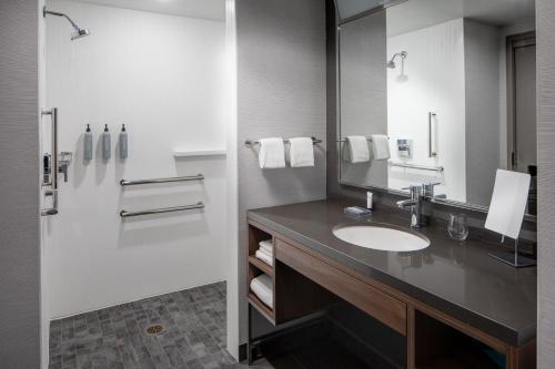 a bathroom with a sink and a mirror and a shower at Courtyard by Marriott Chicago Downtown/River North in Chicago