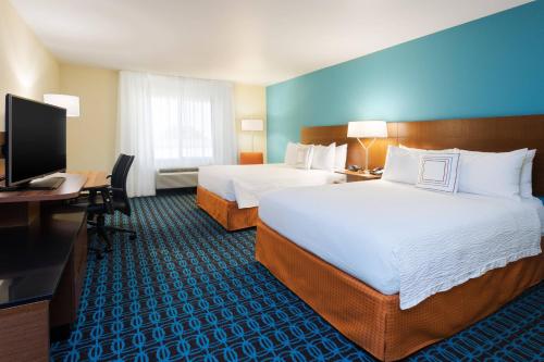 a hotel room with two beds and a desk and a computer at Fairfield Inn & Suites by Marriott Odessa in Odessa