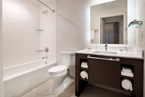 a white bathroom with a toilet and a sink at Residence Inn Los Angeles Glendale in Glendale