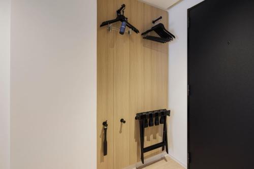 a room with a wooden door with hangers on the wall at Fairfield by Marriott Hiroshima Sera in Sera