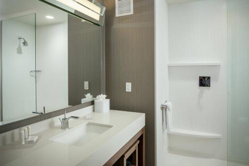 a white bathroom with a sink and a mirror at Courtyard by Marriott Corvallis in Corvallis