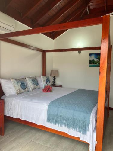 a bedroom with a large bed with a wooden frame at Cozy Oceanfront Room Hidden Treasure in Treasure Beach