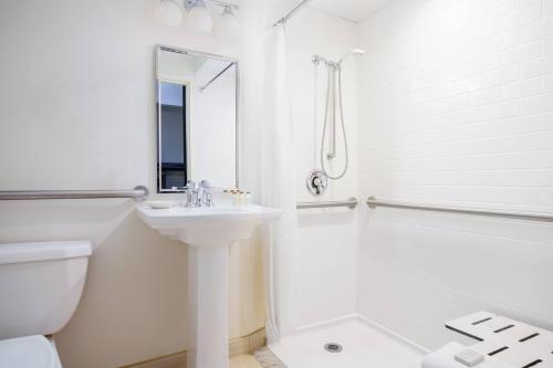 a white bathroom with a sink and a shower at Renaissance Asheville Downtown Hotel in Asheville