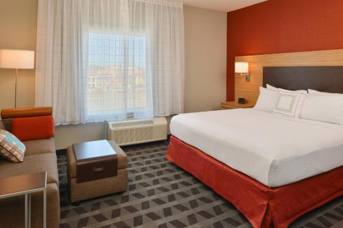 um quarto de hotel com uma cama e uma cadeira em TownePlace Suites by Marriott Laplace em Laplace