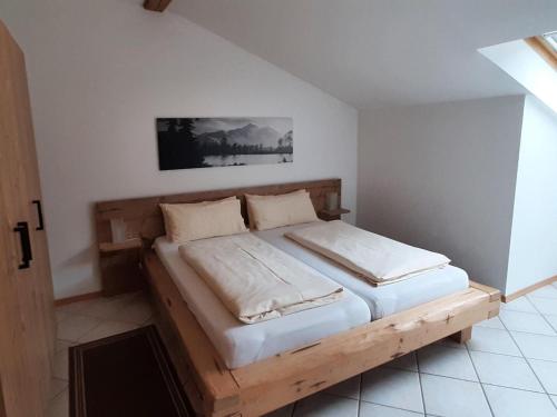 ein Schlafzimmer mit einem Holzbett in einem Zimmer in der Unterkunft Inviting Apartment in Bayrischzell with 2 Sauna, Garden and Terrace in Bayrischzell