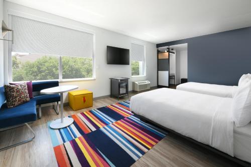 a bedroom with a bed and a couch and a table at Aloft Austin Round Rock in Round Rock