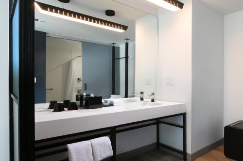 a bathroom with a white sink and a mirror at Aloft Austin Round Rock in Round Rock