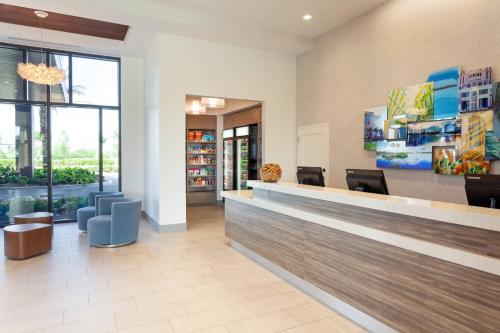 a lobby of a hospital with a reception desk and chairs at SpringHill Suites by Marriott Orlando at Millenia in Orlando