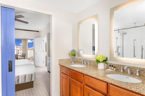 un bagno con due lavandini e una camera con un letto di Marriott's Grande Vista a Orlando
