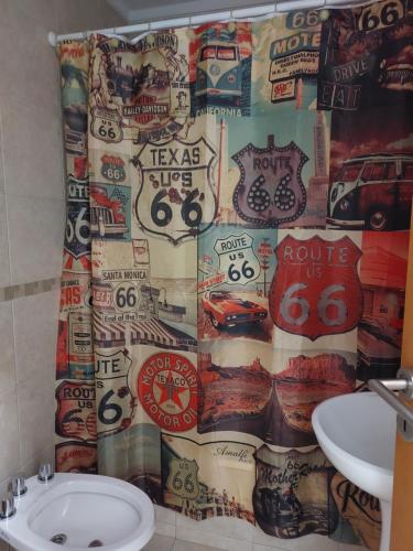 a bathroom with a shower curtain with lots of stickers at Bahia Rental 11-Departamento x dia con cochera in Bahía Blanca