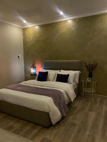 a bedroom with a large bed and a green wall at شقة مفروشة خاصه بالخبر in Al Khobar