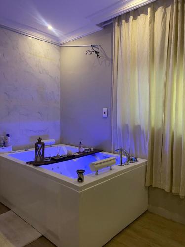 a bathroom with a large bathtub with a blue at شقة مفروشة خاصه بالخبر in Al Khobar