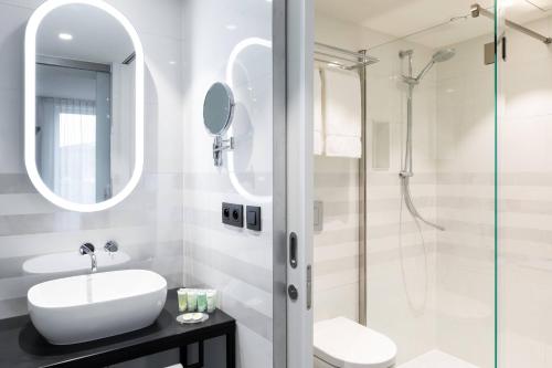 uma casa de banho com um lavatório e um chuveiro em Residence Inn Ghent by Marriott em Gent