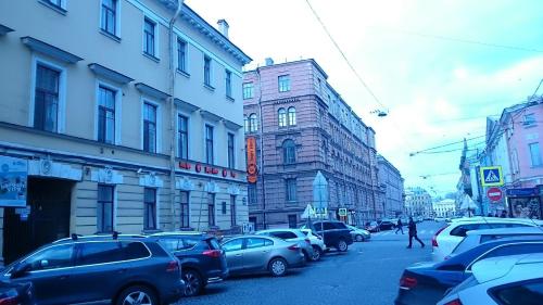 una calle de la ciudad llena de coches y edificios estacionados en Apartments on Italyanskaya, en San Petersburgo