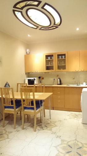 cocina con mesa, sillas y lámpara de araña en Apartments on Italyanskaya, en San Petersburgo