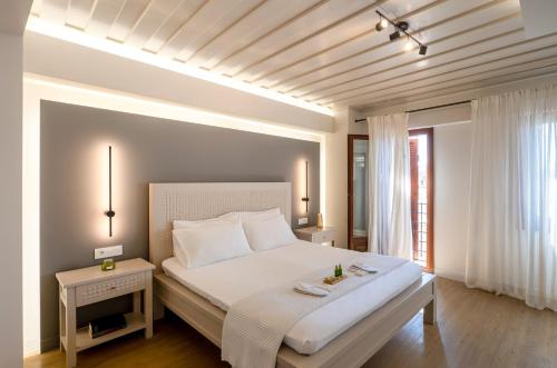 a bedroom with a large white bed and a window at Hanim Boutique Hotel in Chania Town