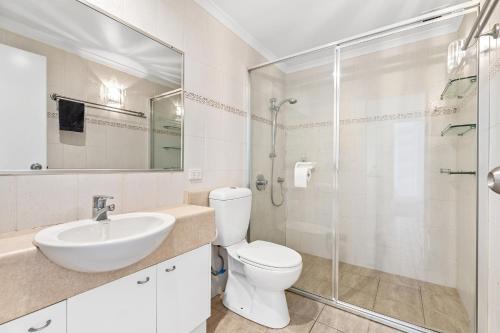 a bathroom with a toilet and a sink and a shower at Como Noosa in Noosaville