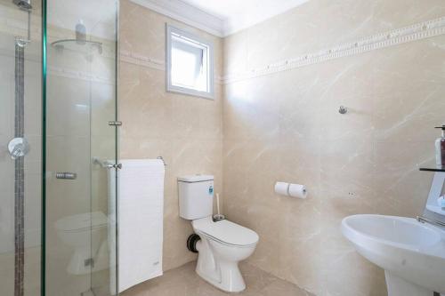 y baño con aseo, lavabo y ducha. en Amazing Views - 3 Bed Malabar en Sídney