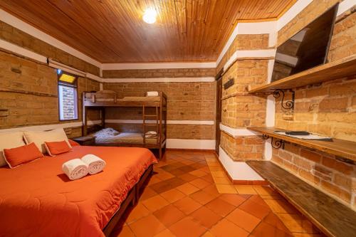 a bedroom with a bed with two towels on it at Hotel Casa Elemento Villa de Leyva in Villa de Leyva