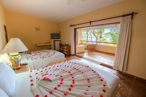 a hotel room with two beds with red hearts on them at Hotel Catalina Beach Resort in Zihuatanejo