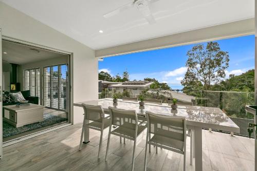 a dining room with a table and chairs on a balcony at North Facing Apartment Unit 2 13 Angler Street Noosa Heads in Noosa Heads