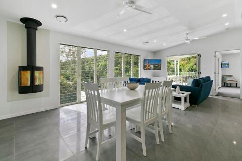 a dining room with a white table and chairs at North Facing Apartment Unit 2 13 Angler Street Noosa Heads in Noosa Heads