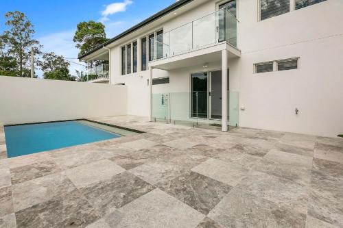 an exterior view of a house with a swimming pool at North Facing Apartment Unit 2 13 Angler Street Noosa Heads in Noosa Heads