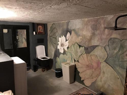 baño con un mural de flores en la pared en Titan House Hostel, en Izmir