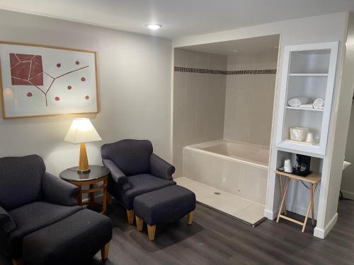 ein Wartezimmer mit 2 Stühlen und einer Badewanne in der Unterkunft Baymont by Wyndham Branford/New Haven in Branford