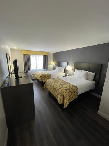 ein Hotelzimmer mit 2 Betten und einem TV in der Unterkunft Baymont by Wyndham Branford/New Haven in Branford