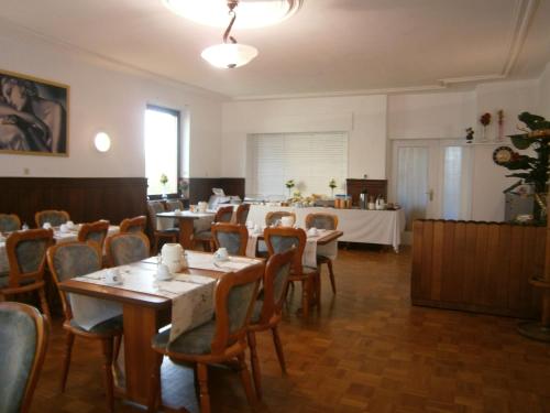 uma sala de jantar com mesas e cadeiras e uma sala com mesa em Hotel Strauss em Waldbronn