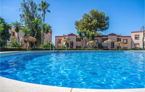 een groot zwembad met parasols voor gebouwen bij Stunning Apartment In Riviera Del Sol With Wifi in Sitio de Calahonda