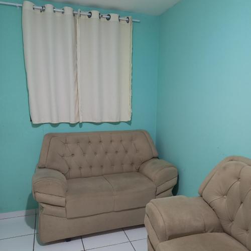 ein Sofa und einen Stuhl in einem Zimmer mit Fenster in der Unterkunft Apartamento temporada in Campina Grande