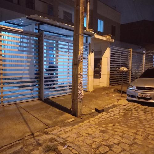 a building with a gate on a street at night at Apartamento temporada in Campina Grande