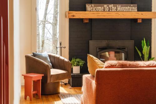 a living room with two chairs and a fireplace at Leaf-Peeping at Oak Ledge! Trails,Tastings,Peace in Lyndhurst