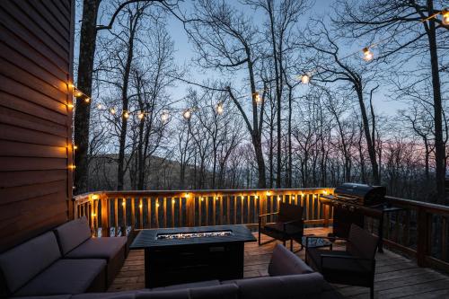 a deck with a table and chairs and lights at Leaf-Peeping at Oak Ledge! Trails,Tastings,Peace in Lyndhurst