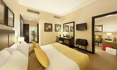 um quarto de hotel com uma cama grande e uma secretária em ALMASSA FOR APARTMENTS em Kuwait