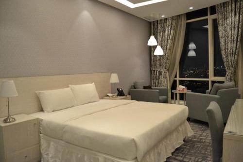um quarto com uma cama grande e uma sala de estar em ALMASSA FOR APARTMENTS em Kuwait