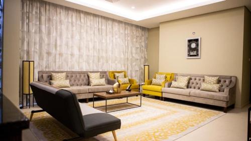 a living room with two couches and a table at ALMASSA FOR APARTMENTS in Kuwait