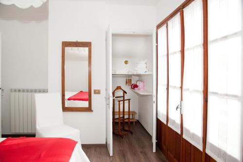 a bedroom with a red bed and a mirror at Chalet La Primula in Santa Maria Maggiore