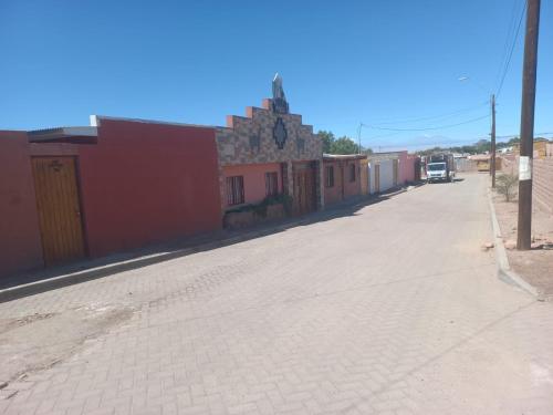 an empty street in a town with a building at hostal casa talitha in San Pedro de Atacama